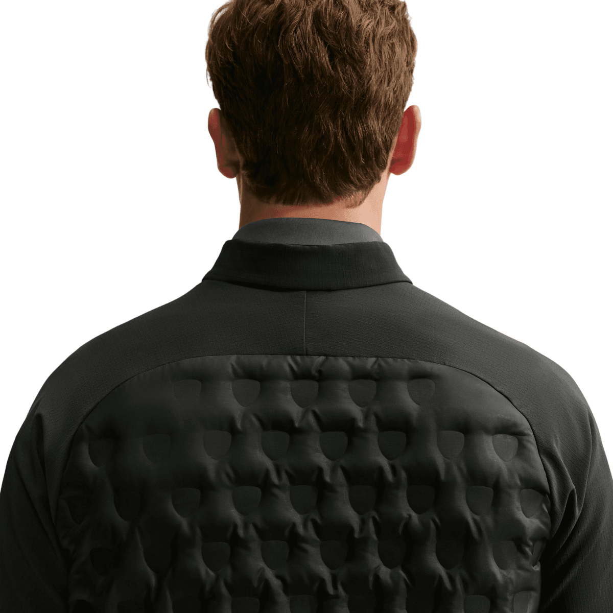 Rear view of a man wearing a black quilted jacket with a high collar, showing the textured bubble pattern on the back against a light gray background.