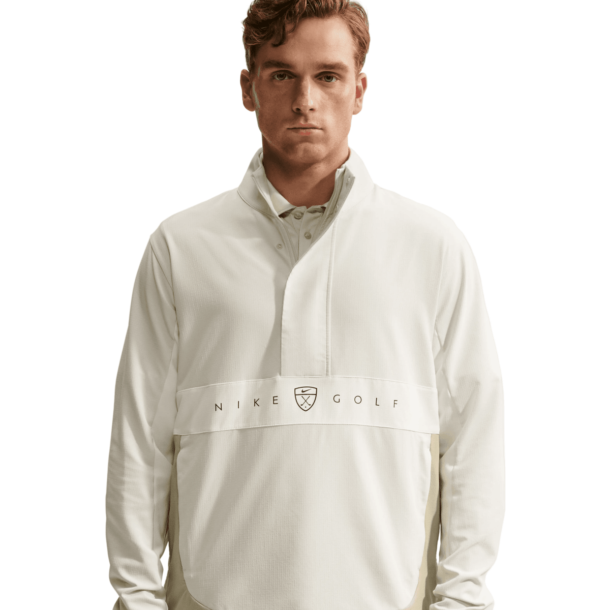 A man wearing a white Nike Golf long-sleeve half-zip pullover jacket with a high collar and a horizontal chest logo band, photographed against a clean light gray studio background.