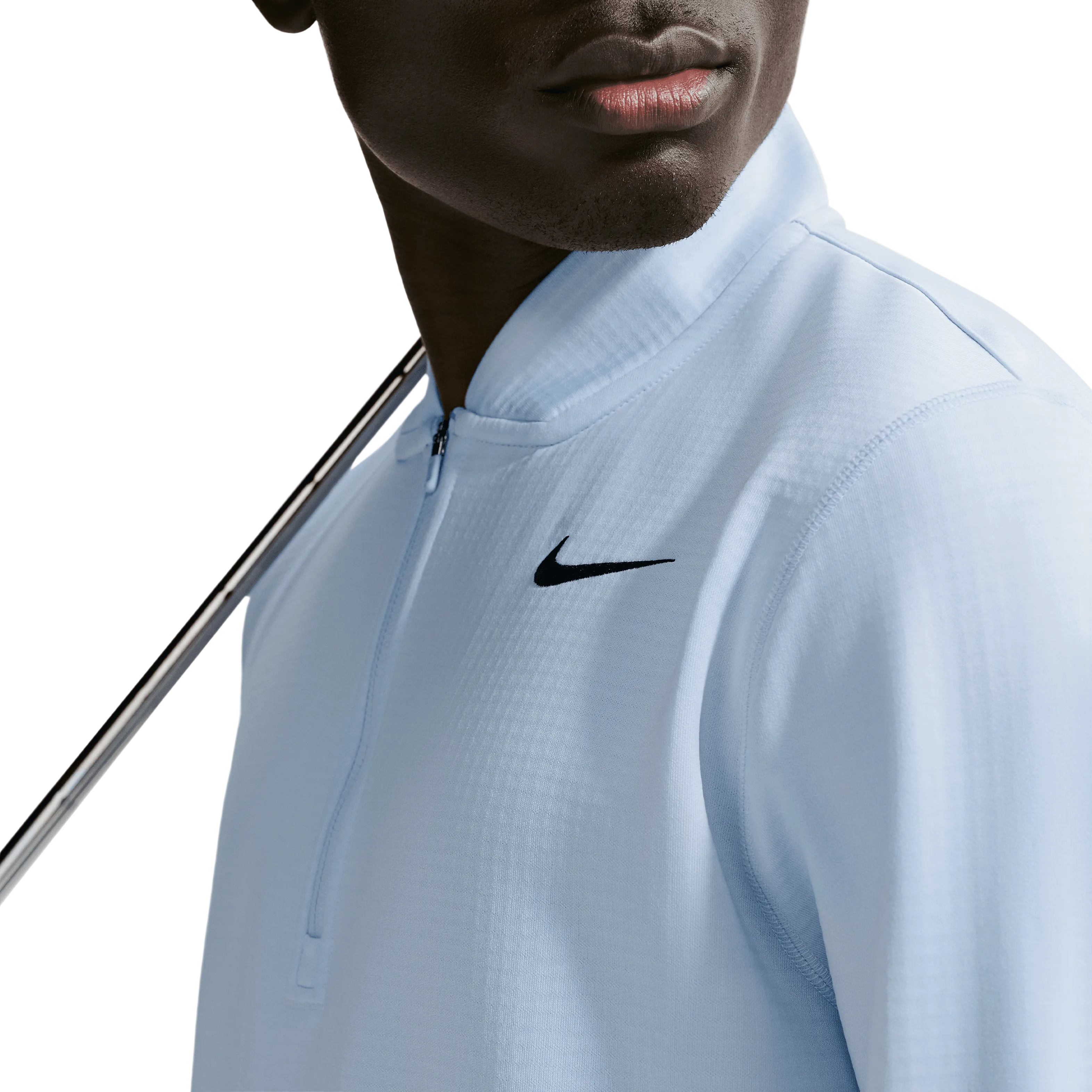 Person wearing a light blue athletic jacket with a nike logo on a neutral background