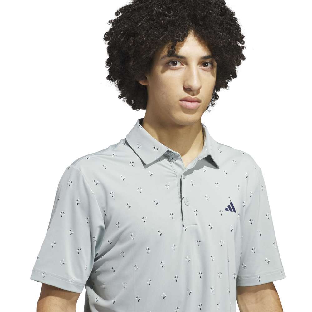 Light sage polo shirt with subtle pattern and Adidas logo on a white background